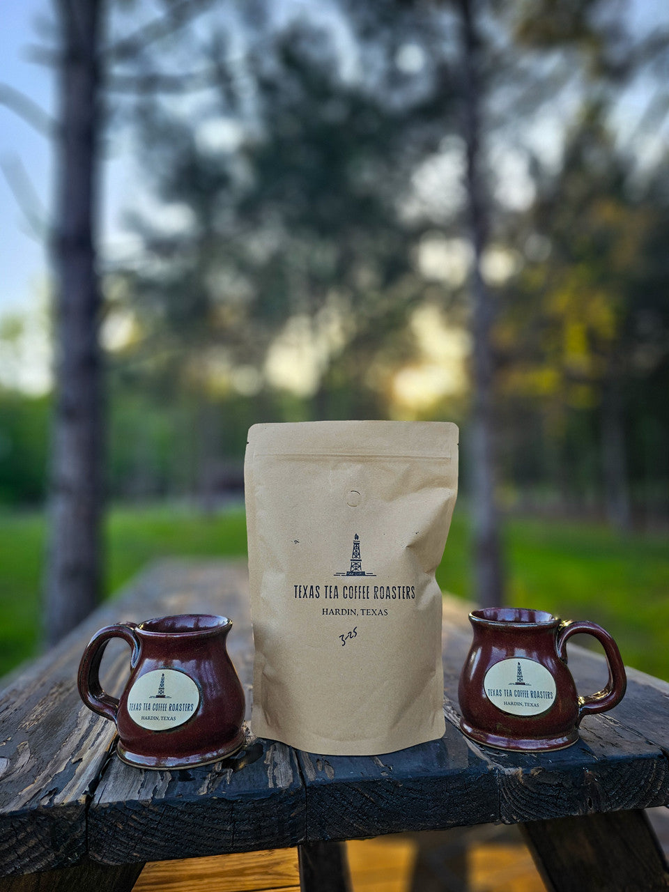 stoneware mugs and coffee bag, woods and sunset in background